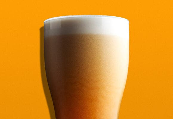 A glass of Nitro Beer on an orange background