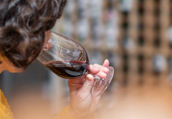 Woman smelling glass of red wine