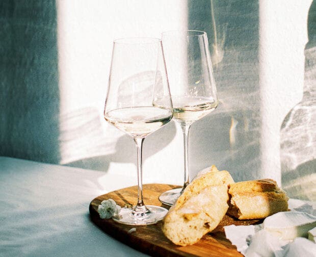 wine with fresh french bread and cheese during sunset time indoors