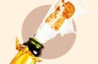 Close up of a champagne bottle popping on a tan background