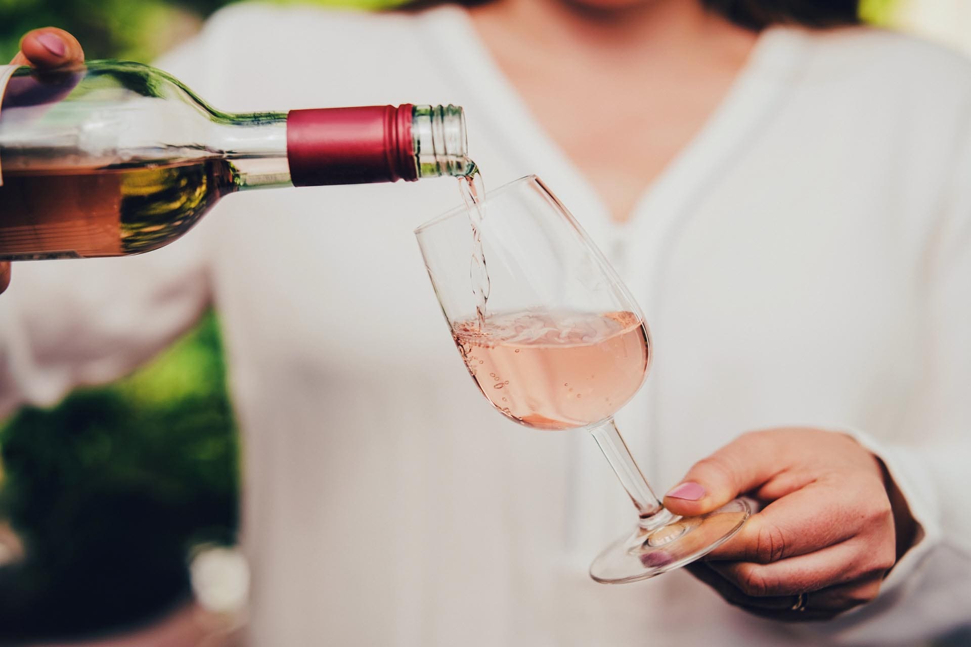 Woman pouring wine in glass.