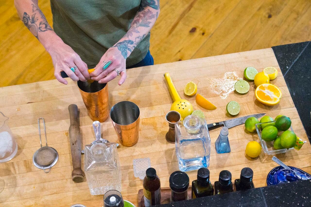 A couple mixes cocktails in their kitchen of their home.